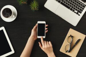 Woman's hands holding a smartphone, top view