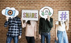 Friends holding up thought bubbles with social media concept ico