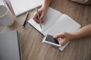 Woman’s hand writing on notebook