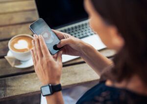 Woman taking photo of coffee with smartphone