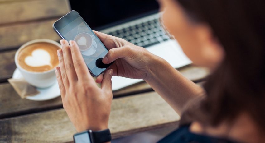 Woman taking photo of coffee with smartphone